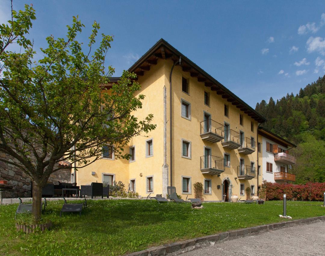 Giardino rustico con sedie, sole splendente, montagne verdi: un'oasi di pace e serenità.