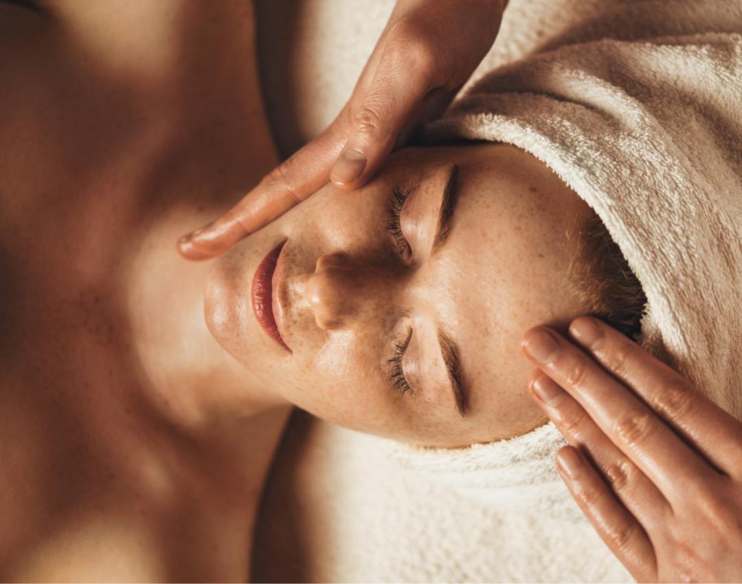 Massaggio rilassante al viso, mani delicate, pelle serena, atmosfera di benessere e tranquillità.