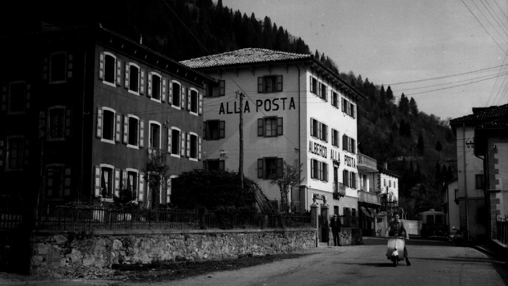 Gruppo di ciclisti in gara, folla entusiasta lungo la strada, atmosfera di competizione e festa.