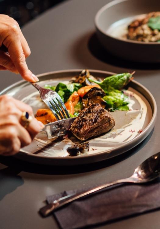 Un piatto elegante con carne succosa e verdure fresche, tagliato con cura e piacere.