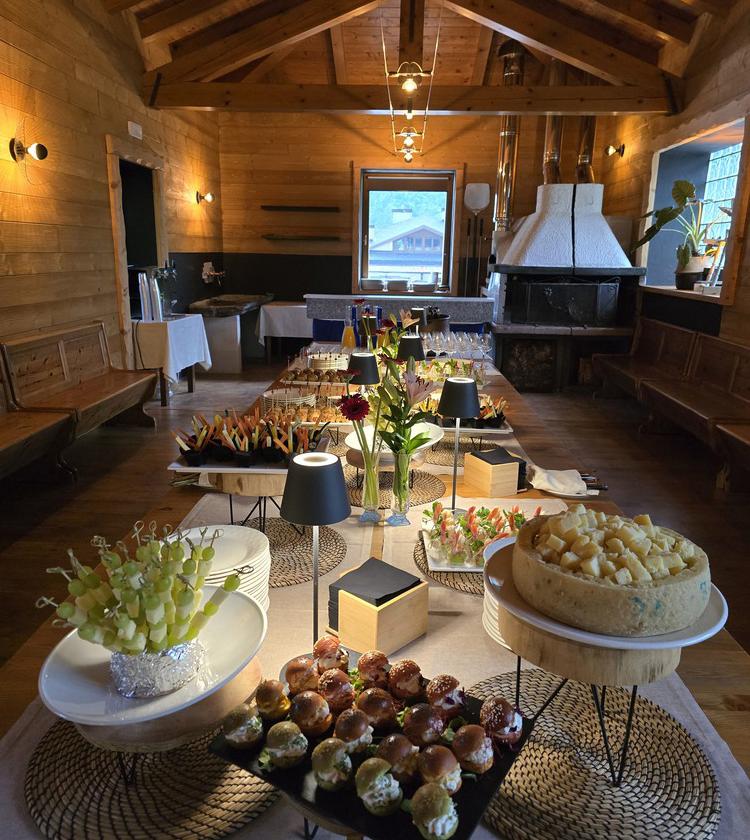 Elegante sala in legno con buffet di stuzzichini e formaggi, atmosfera accogliente e raffinata.