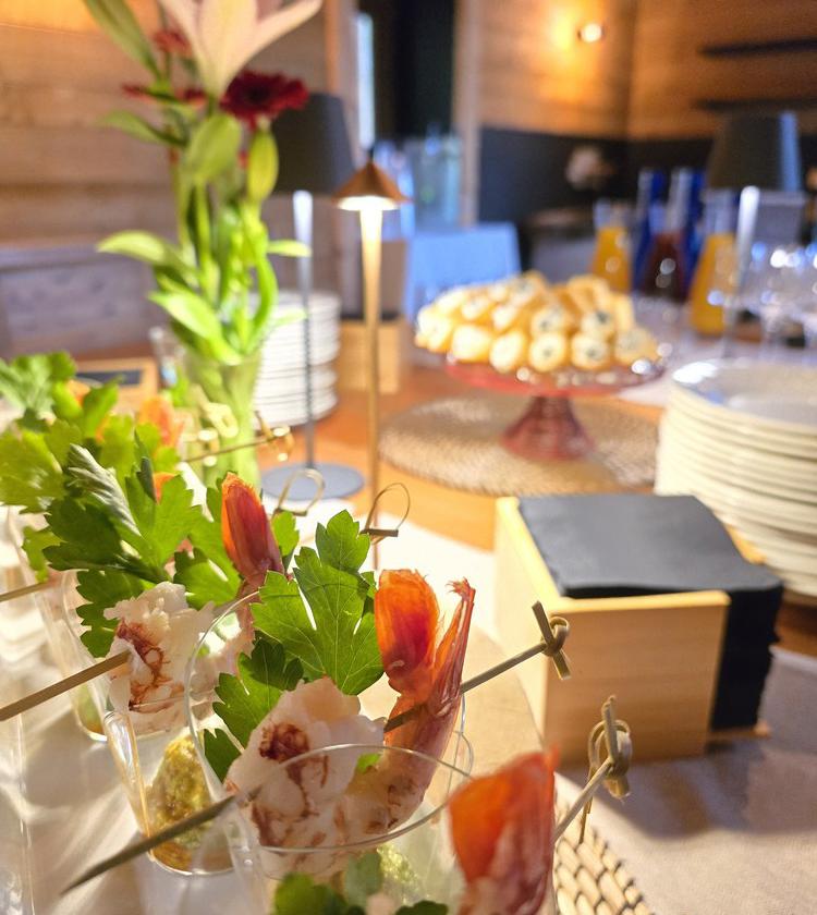 Elegante buffet con fiori, stuzzichini raffinati e atmosfera calda e accogliente.
