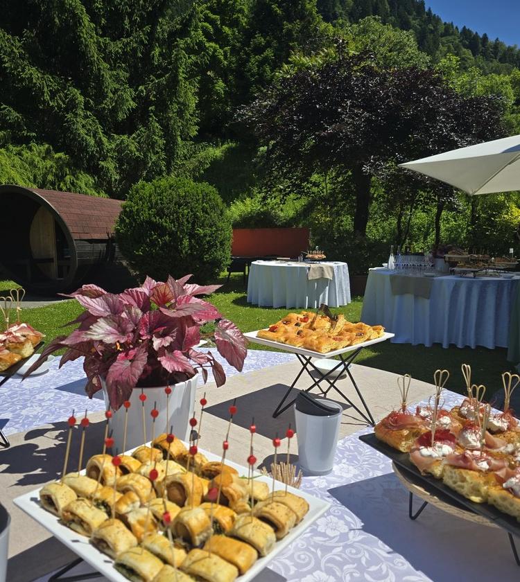 Buffet all'aperto con stuzzichini colorati, natura rigogliosa e atmosfera festosa.